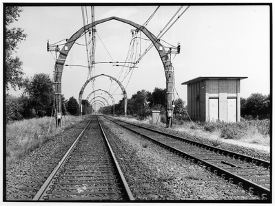 837553 Gezicht op de spoorlijn nabij Hollandsche Rading met de karakteristieke, betonnen bovenleidingsportalen. Rechts ...